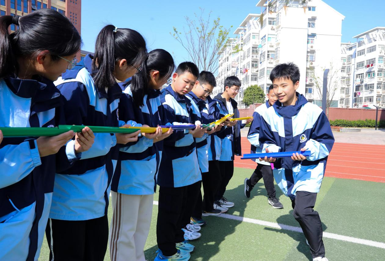 (图为:2025年3月25日,在安徽省合肥市肥西县上派镇安徽师范大学附属肥西第二中学校园内,学生们利用阳光大课间时间在操场上开展“球行万里”心理团辅游戏。)