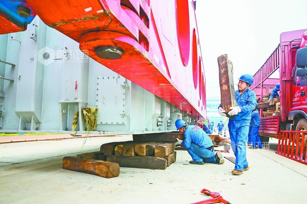 工作人员给变压器垫上枕木，以便拆解其他附件。