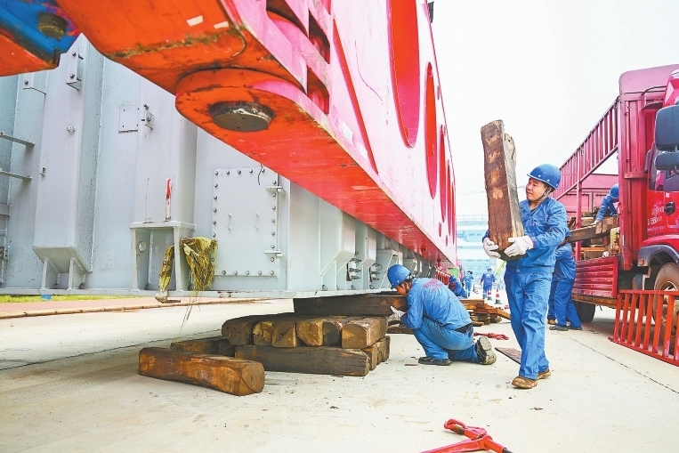 工作人员给变压器垫上枕木,以便拆解其他附件。