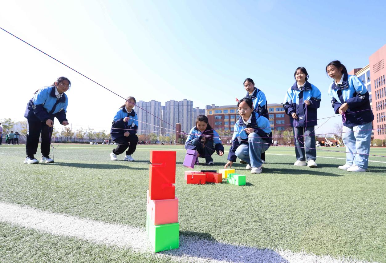 (图为:2025年3月25日,在安徽省合肥市肥西县上派镇安徽师范大学附属肥西第二中学校园内,学生们利用阳光大课间时间在操场上开展“合力筑塔”心理团辅游戏。)