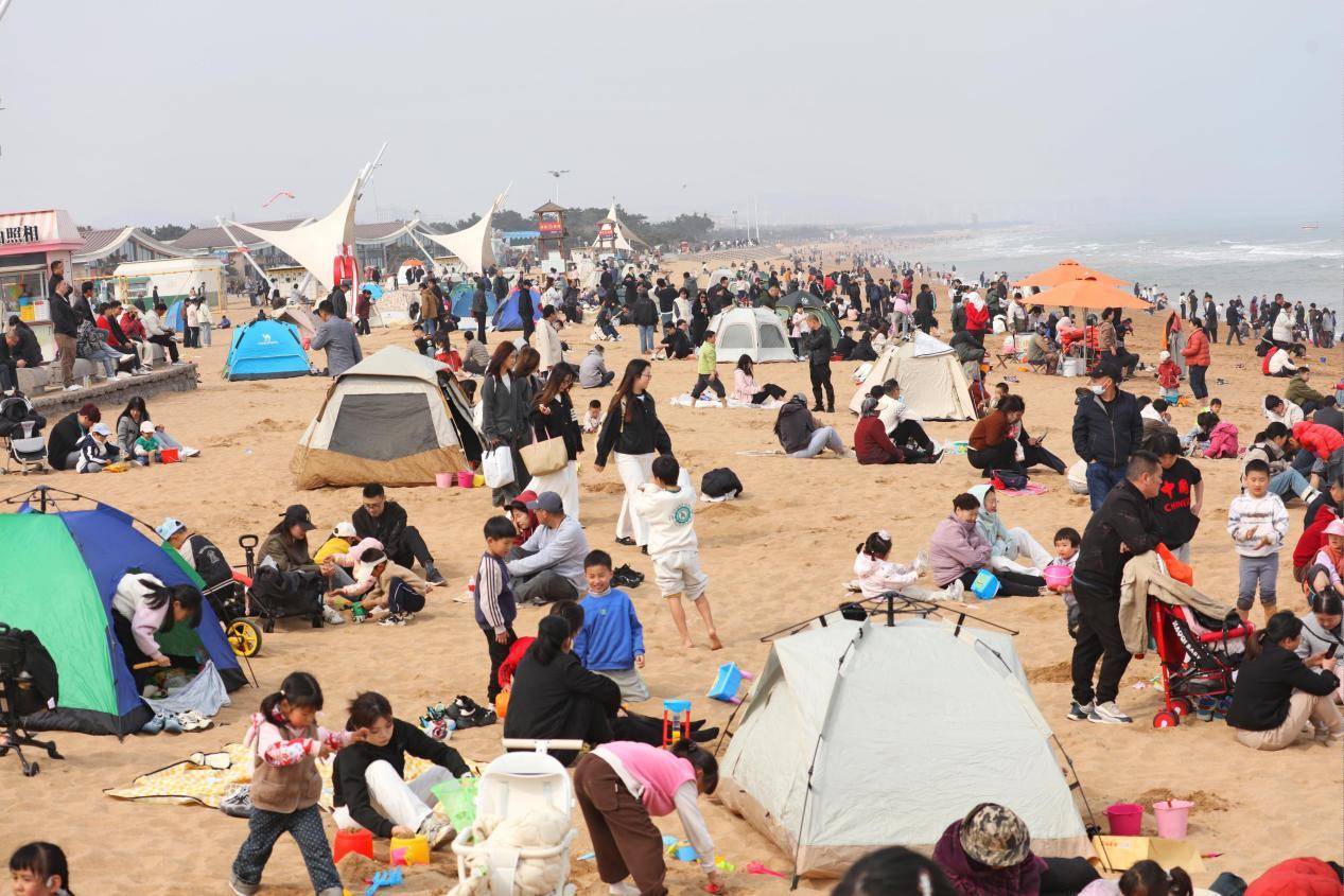 气温适宜，沙滩上五颜六色的帐篷格外靓丽，孩子们尽情嬉戏。张守本 摄