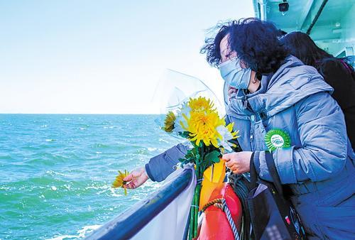 3月30日,在2025年京津冀海葬启航活动中,逝者家属将花瓣撒入大海。 本报记者 李东宇摄