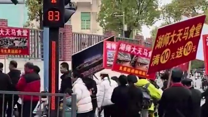 高校食堂在校门口举牌揽客：生意难做，虽然简单粗暴，但是个好办法