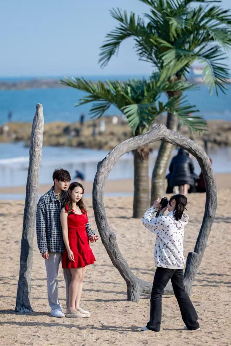 微风轻拂，年轻人相聚在沙滩拍照打卡。刘晶 摄