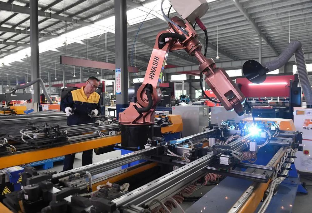 金虎集团智能化生产车间内，技术人员在金属板材柔性生产线上作业。（肖龑 摄）