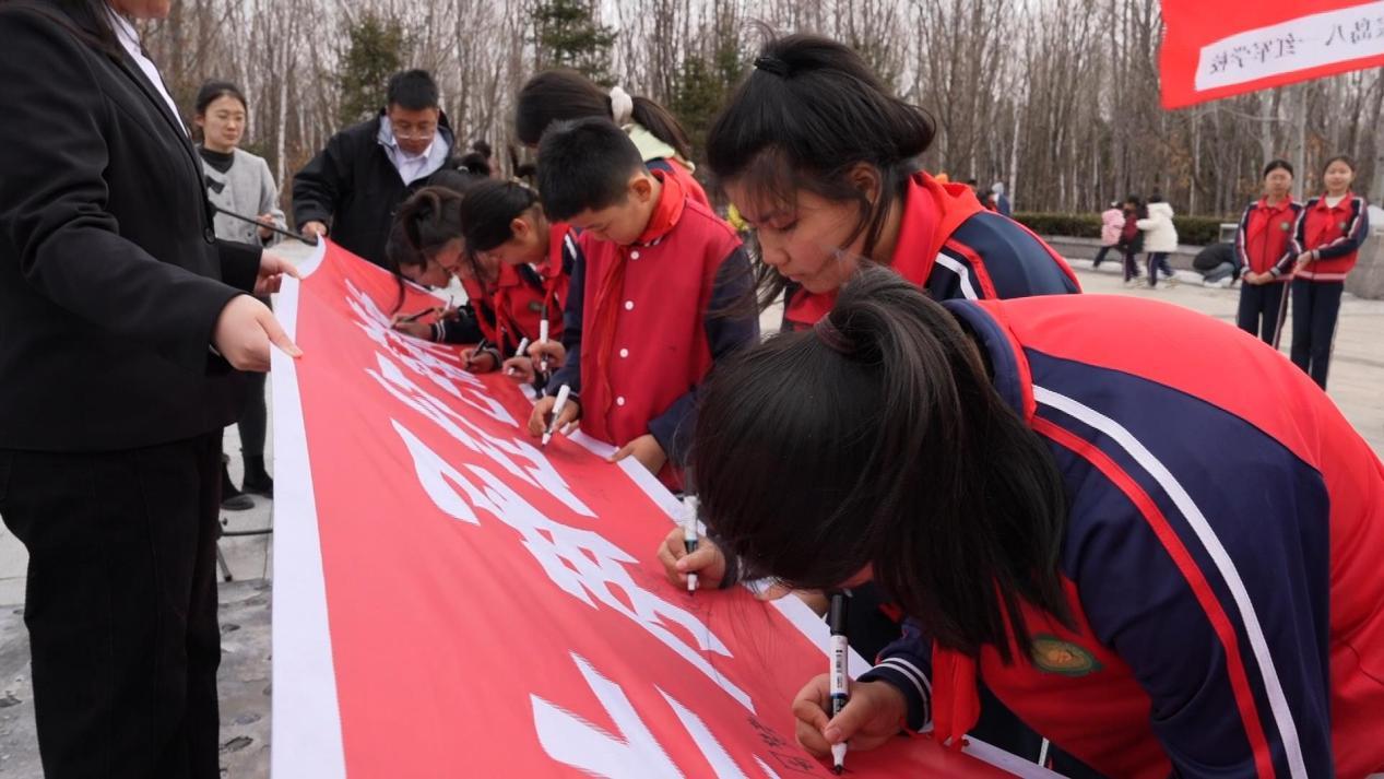 （珍宝岛八一红军小学学生们在红色条幅上签字）