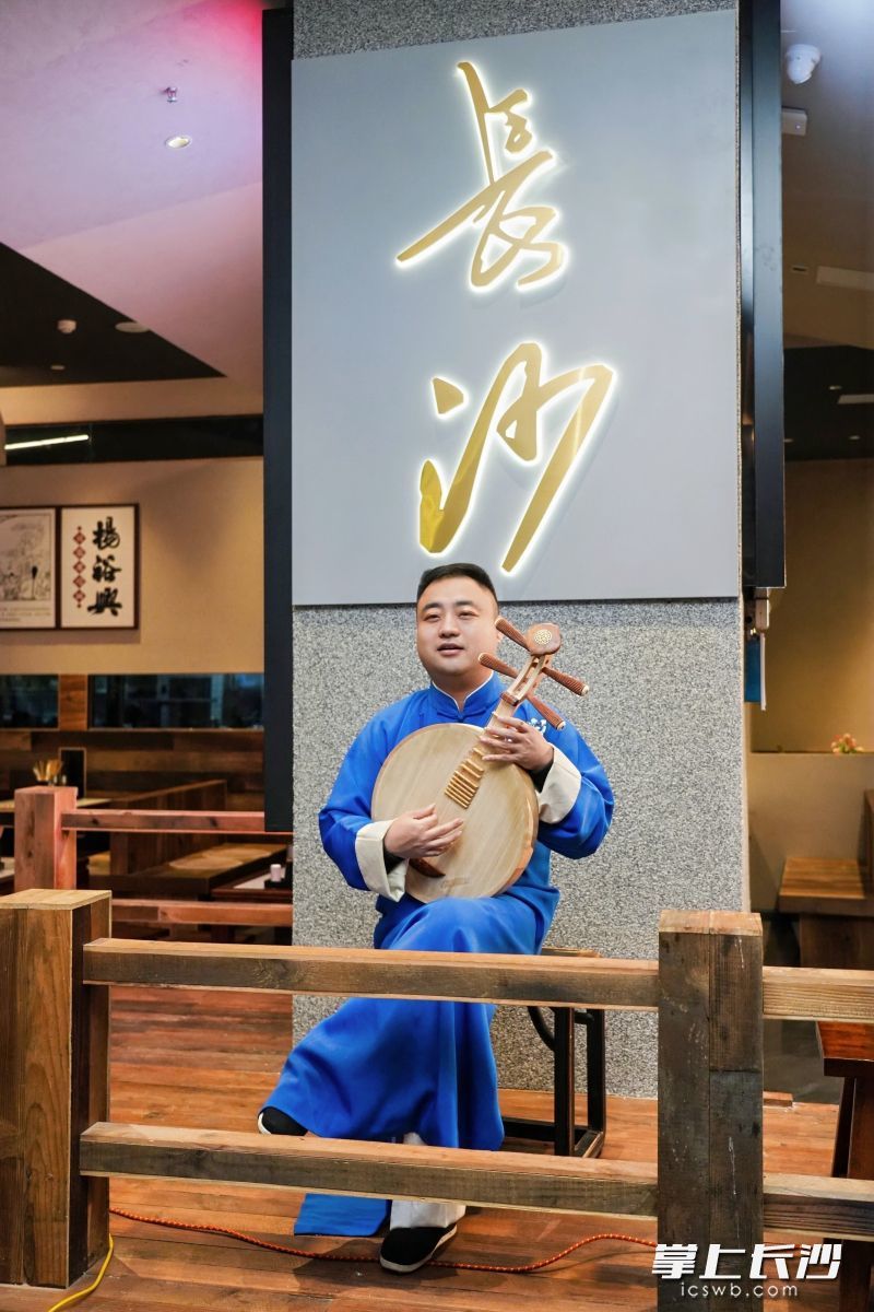 “长沙弹词”传承人王志敏拨动月琴，一曲民谣唱响：“杨裕兴的面，徐长兴的鸭，德园的包子咯么大一只（音扎）……”
