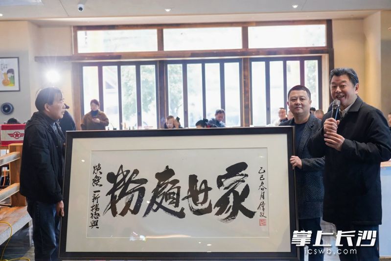 长沙餐饮协会会长、湘菜大师任伟政挥毫写下“粉面世家”，墨香中寄寓对杨裕兴重振辉煌的期待。