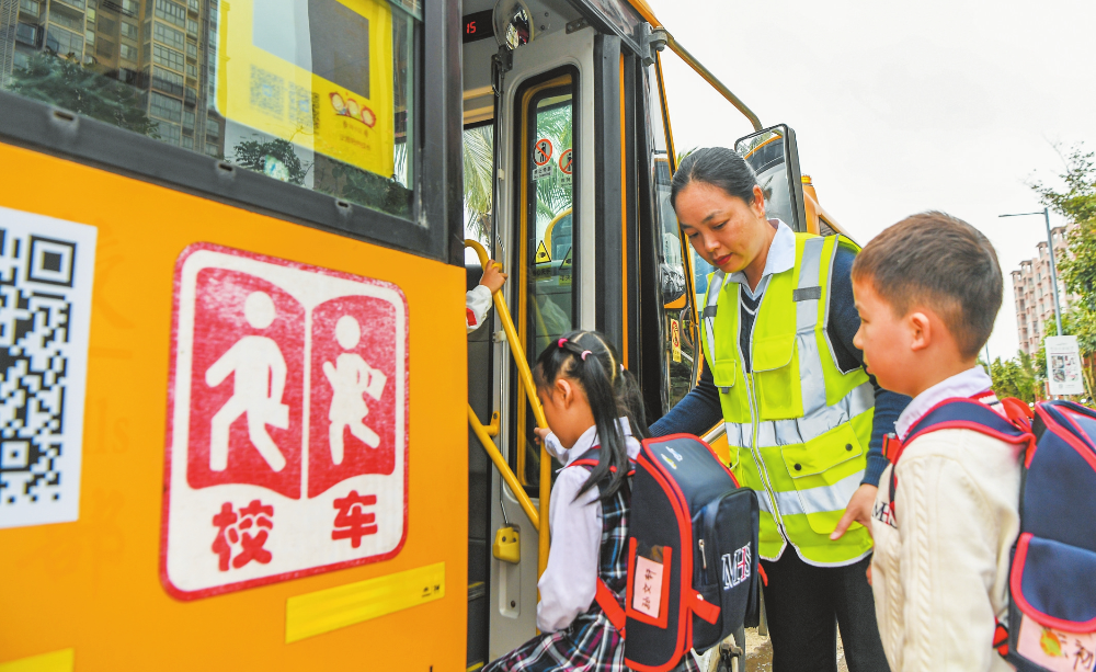 3月10日，观澜湖幼儿园校车照管员正在引导小朋友们有序登上校车。海口日报记者 康登淋 摄