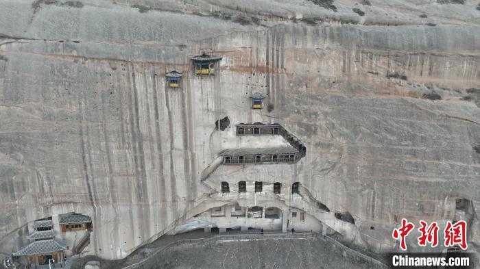 4月8日,甘肃张掖市,悬崖峭壁上的马蹄寺石窟。无人机照片 九美旦增 摄