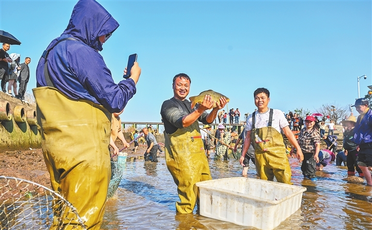 3月15日，南丰县市山镇包坊村，网红“大表哥”熊涛（左二）在录播现场展示刚抓到的活鱼。