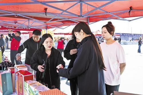 4月2日，在威县梨园的农产品展台，游客们正在品尝“良材记”的秋月梨醋。 本报记者 王永晨摄