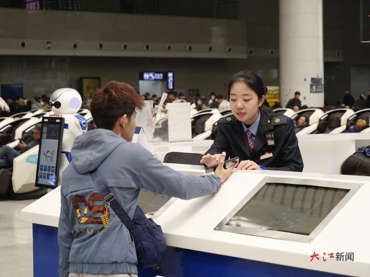 南昌站“红土情”服务台工作人员正在为旅客答疑。薛雅婧 摄