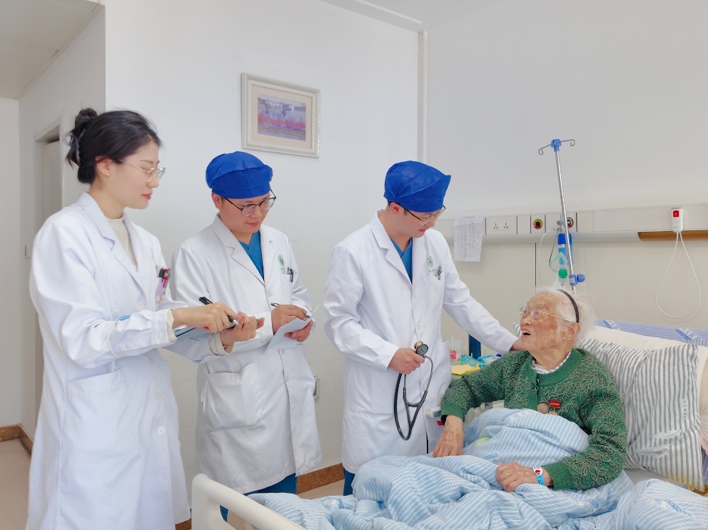 许铭副主任医师带领团队为许奶奶查房。王倩 摄