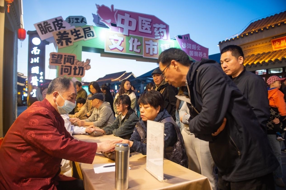 沧州中西医结合医院中医专家在市集上义诊。