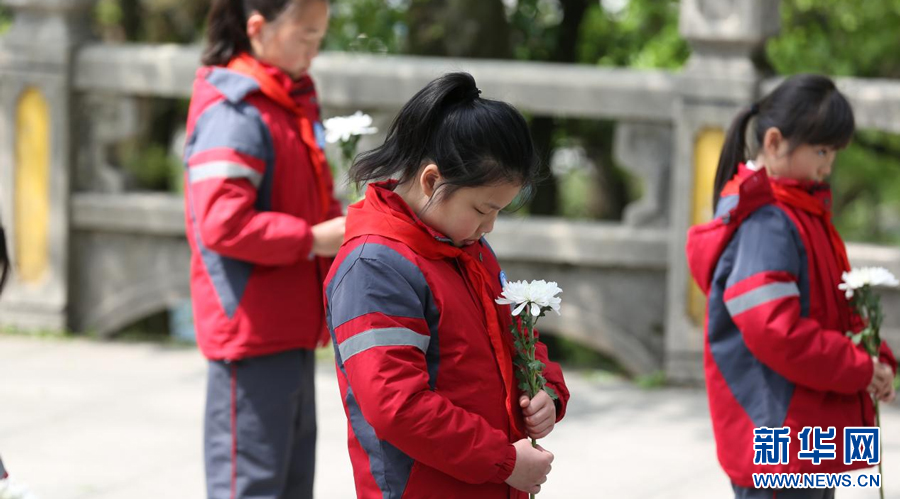 余干县第八小学的同学们手持花朵，缅怀革命先烈。新华网发 韩海建 摄