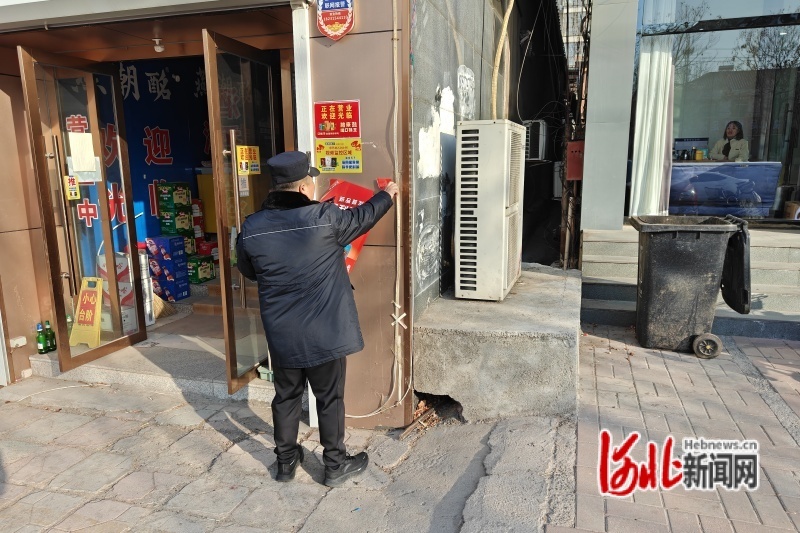 图为工作人员正在清理小广告。遵化市城管局供图