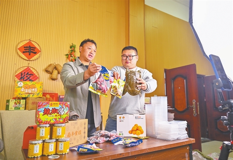 熊涛（左）和团队的小伙伴在直播销售南丰甲鱼等土特产品。