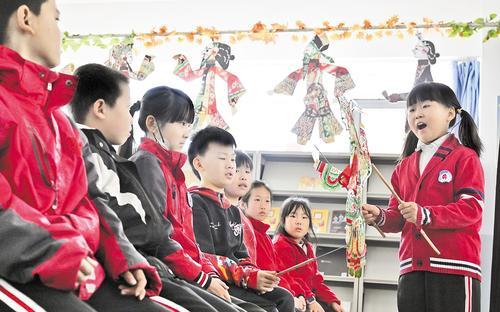 4月3日，苏梓涵（右一）为同学们表演滦州皮影。