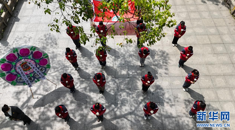 余干县第八小学的同学们手持花朵，缅怀革命先烈。新华网发 韩海建 摄