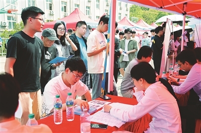 许多高校毕业生在招聘会现场面试