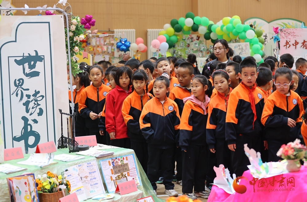 同学们在校园读书节上参观各个年级师生制作的读书笔记、手抄报,分享创作心得与体会。