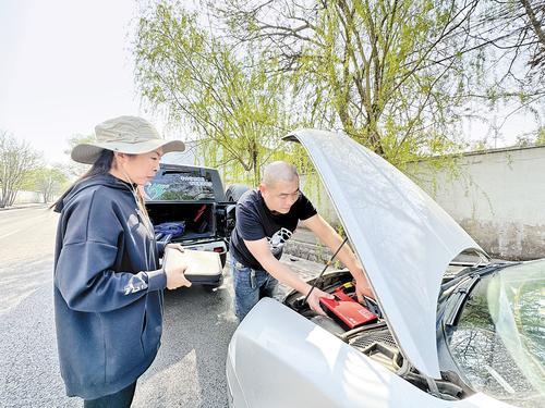 4月10日上午，唐山众一救援队爱心私家车主李剑（右）、爱心救护志愿者刘旭蕊对记者驾驶的车辆进行电源强启救援。 本报记者 汤润清摄