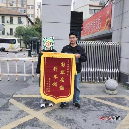 患者为邓石明(右)送上锦旗。(江西中医药大学供图)