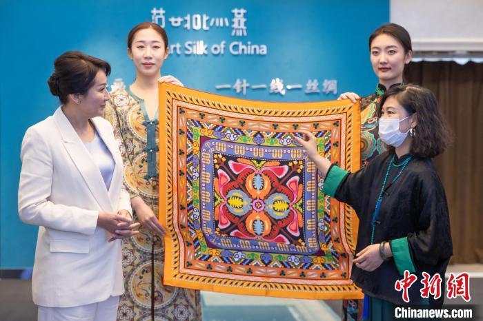 图为范燕燕(右一)向外宾介绍丝巾艺术作品(资料图)　敦煌市委宣传部供图