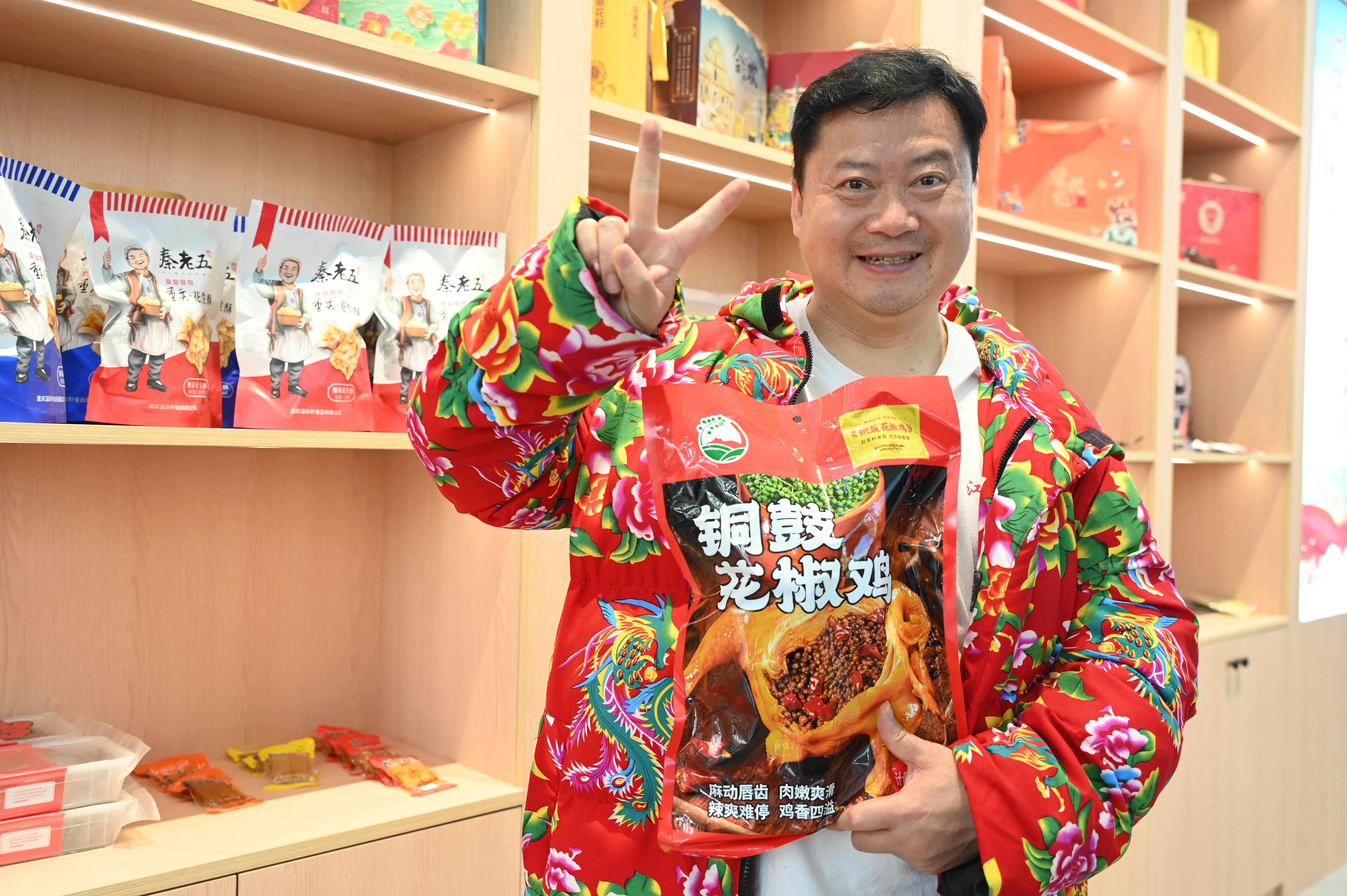 “卤鹅哥”林江穿着大花袄，手拿荣昌特产。上游新闻记者 钱波 摄