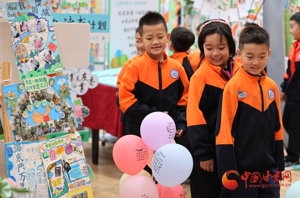 同学们在校园读书节上参观各个年级师生制作的读书笔记、手抄报,分享创作心得与体会。