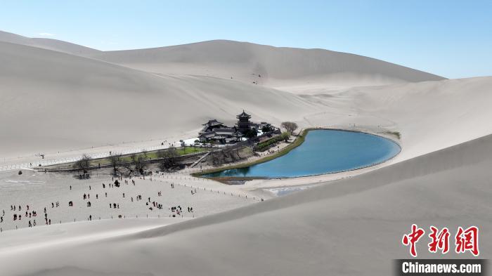 4月11日,甘肃敦煌,中外嘉宾观赏月牙泉。(无人机照片) 九美旦增 摄