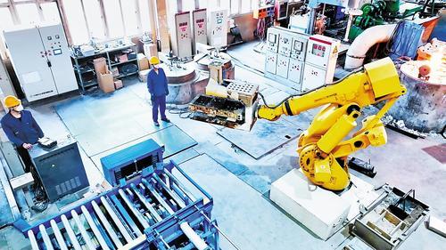 4月11日，在中煤张煤机公司铸造分厂生产车间内，技术工人操作机械臂进行浇铸作业。张 蕾摄