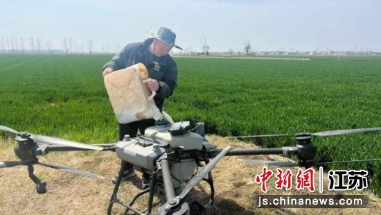 工作人员向无人机添加肥料。睢宁县融媒体中心供图
