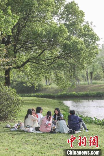 4月13日，江西南昌高新区艾溪湖湿地公园，市民在公园草坪上野餐。当日南昌天气晴好，艾溪湖湿地公园绿意盎然，不少市民来到公园游玩，乐享周末悠闲时光。中新社记者 刘力鑫 摄