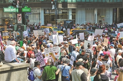 4月19日，美国多地民众走上街头，抗议现政府加征关税、大规模裁员等政策。图为当天，人们在美国纽约街头参加抗议活动。新华社记者 刘亚南摄