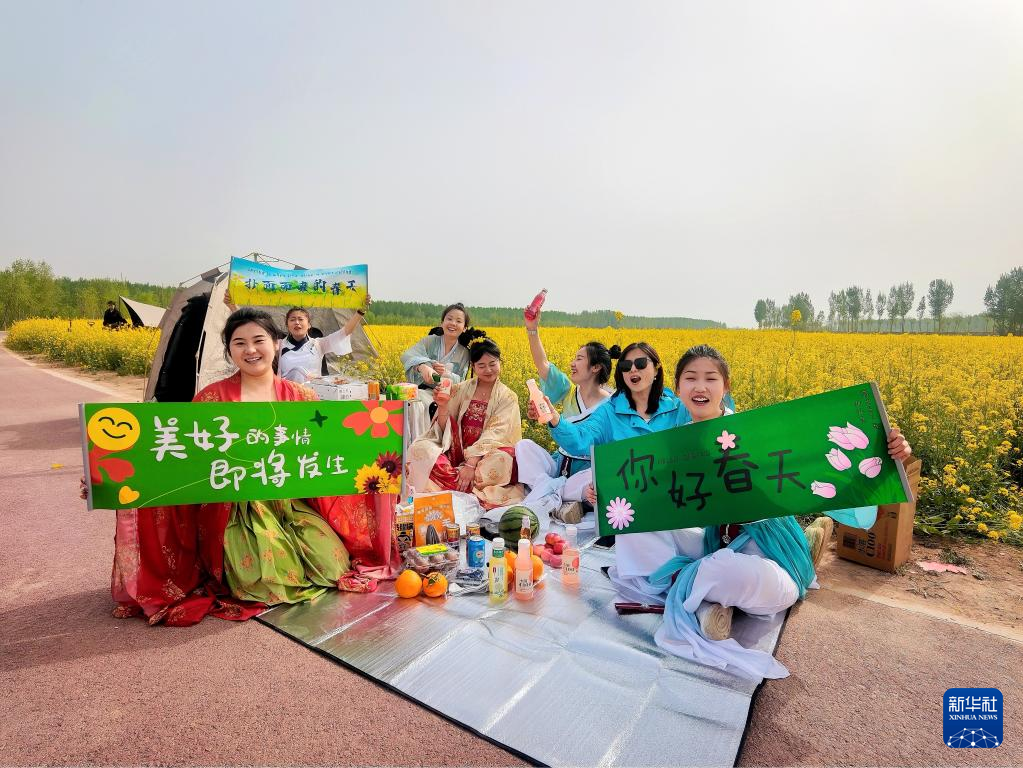 4月15日，游客在南皮县堤顶路沿线的油菜花田打卡拍照。（受访单位供图）