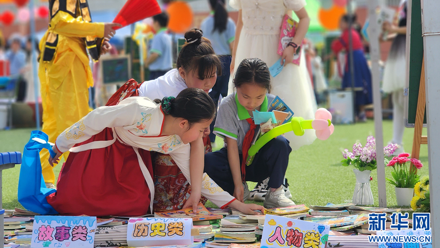 4月18日，在南阳市第二完全学校举办的图书淘宝市场活动中，孩子们正在挑选心仪的书籍。
