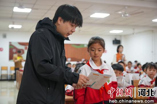 图为任丘市第四实验小学，工作人员正在发放版权宣传册。 韩慧峰 摄