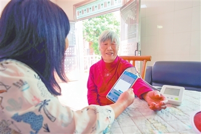 健康管理员上门为慢性病患者量血压。　　本报全媒体记者 付 强摄