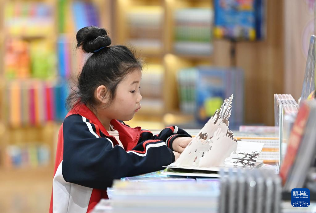 4月22日，小朋友在山东省滕州市书城阅读。新华社发（李志军摄）