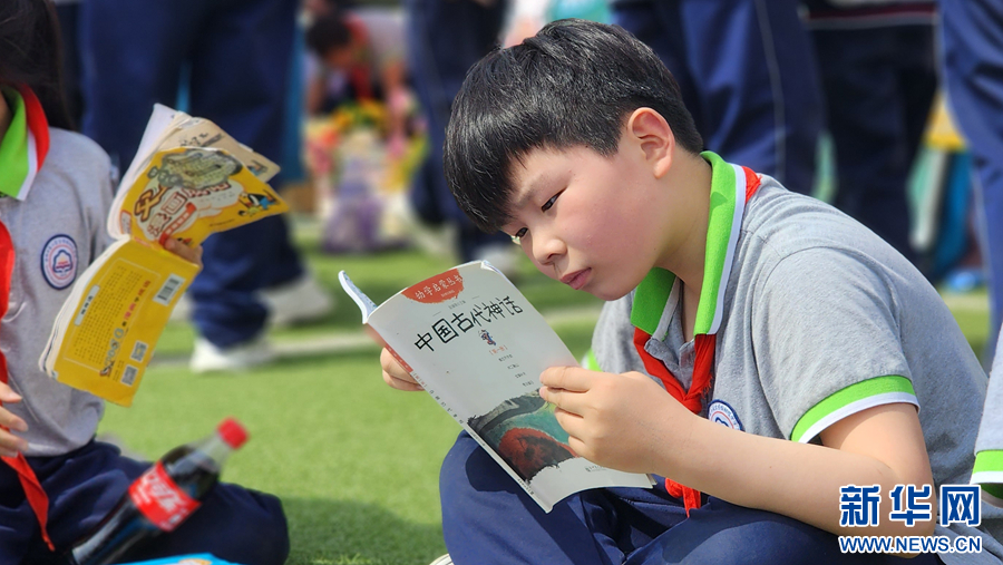 4月18日，在南阳市第二完全学校，孩子们正在阅读挑选好的书籍。