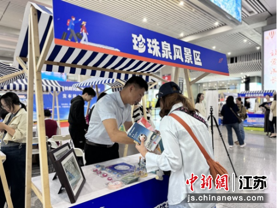 工作人员向旅客介绍景区特色。葛勇 摄