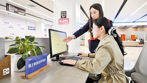 4月21日,在张家口市政务服务中心办事大厅,工作人员(站立者)在帮助民营企业办事人员办理业务。 本报记者 郭晓通摄