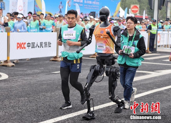 2025年4月19日7点30分，全球首个人形机器人半程马拉松在北京亦庄鸣枪开跑。图为机器人赛队陆续出发。中新社记者 贾天勇 摄