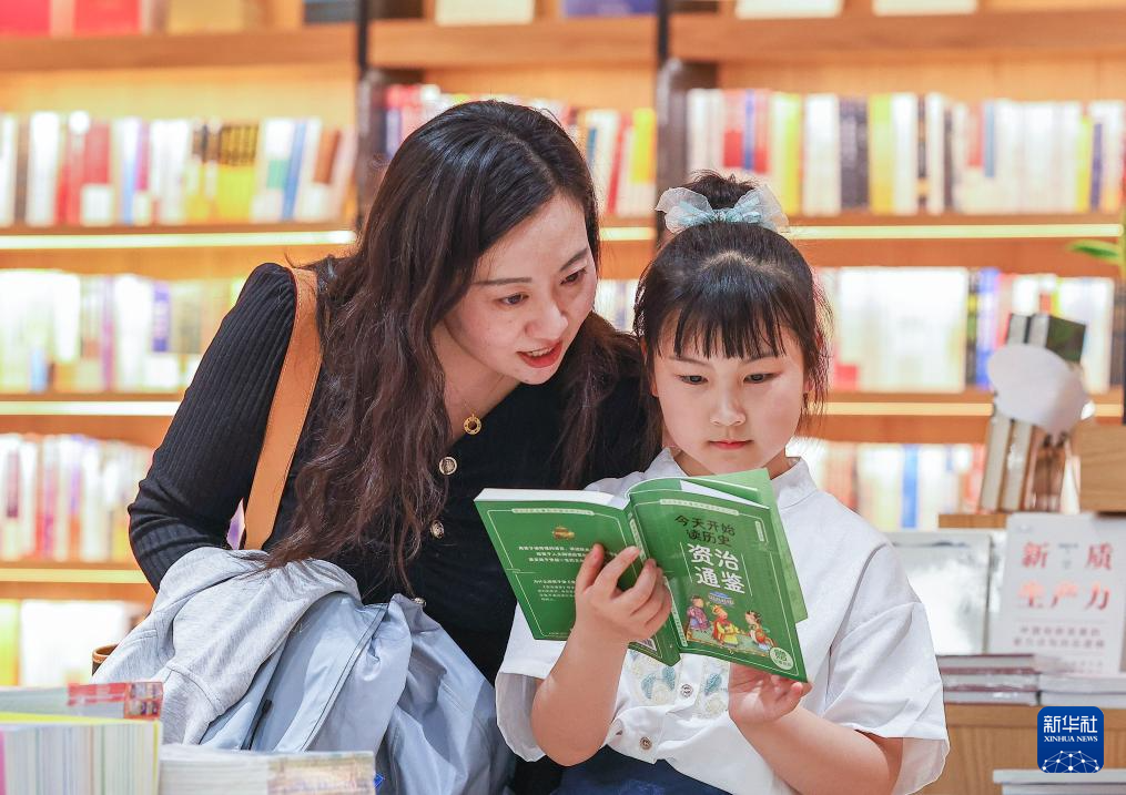 4月22日，小朋友和家长在江苏省镇江市京口区一家新华书店内阅读。新华社发（辛一摄）