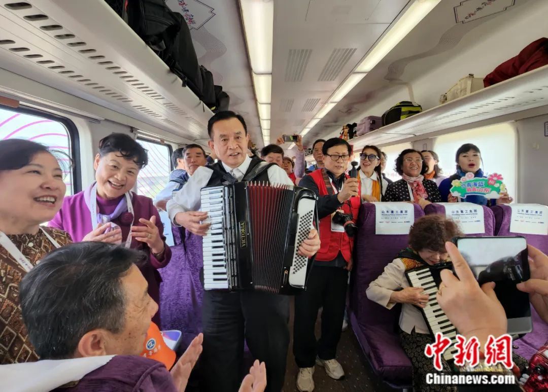 在首发当日，“银发”乘客拉着手风琴、唱着歌，庆祝列车投入运营。赵晓 摄