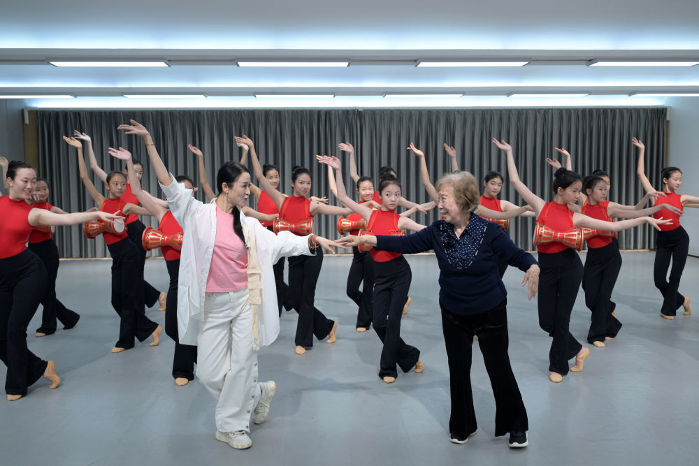 4月25日，高金荣（前右）、北京师范大学附属中学金帆舞蹈团团长齐峰（前左）为学生示范舞蹈动作。