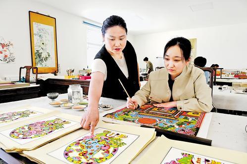 4月23日，武强县汇名轩年画非遗工坊年画艺人杨艳飞（左）和工友讨论新年画创作。 本报记者焦磊摄
