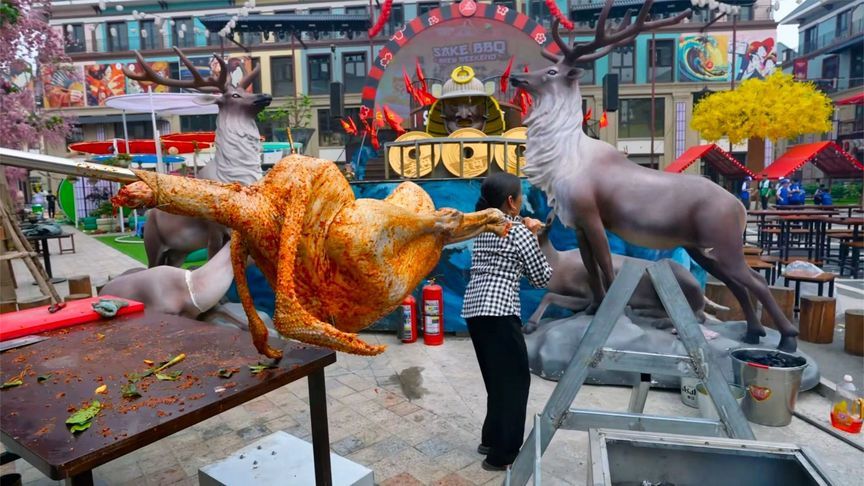 越南人当街烤一只巨大的鸵鸟，两个人抬都费劲，烹饪是个苦力活